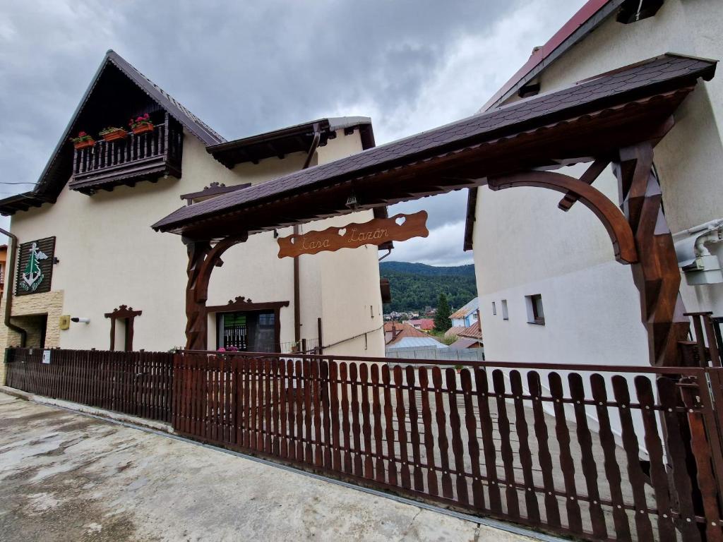 a building with a wooden fence in front of it at Casa Lazar in Buşteni