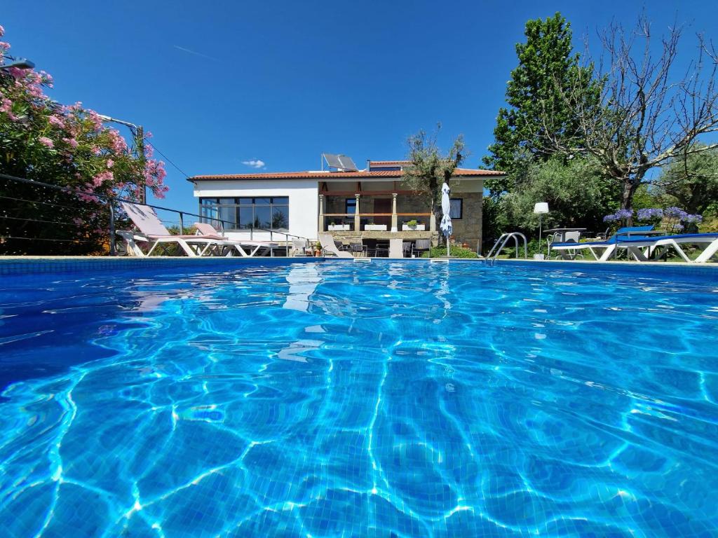 a large swimming pool in front of a house at Casa Branca in Covas