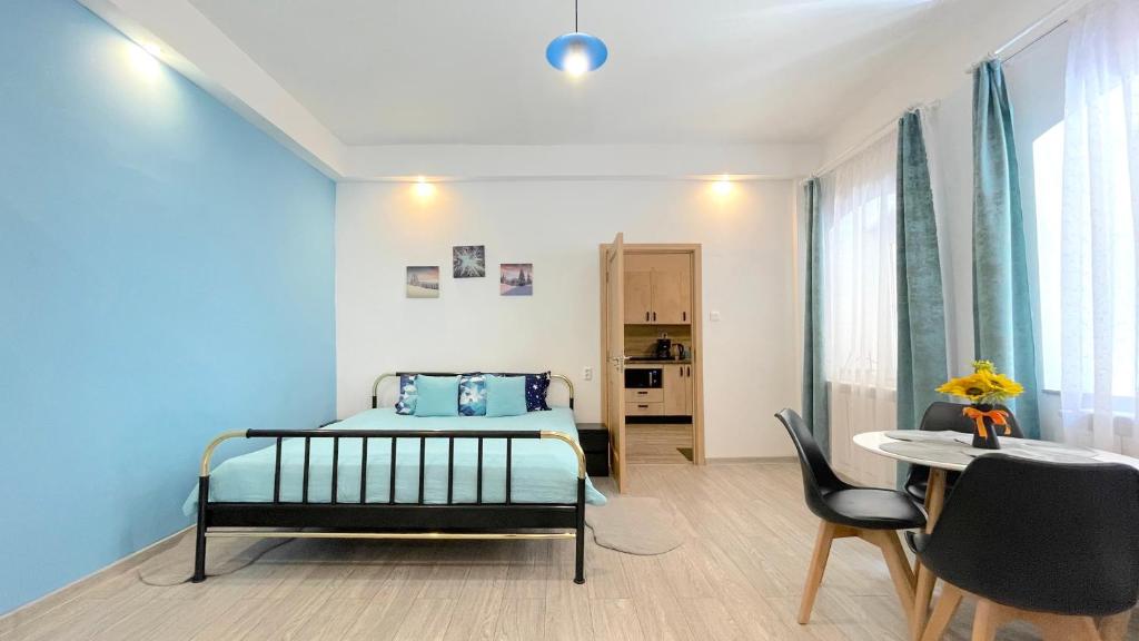 um quarto com uma cama, uma mesa e cadeiras em EVU Long Street em Braşov