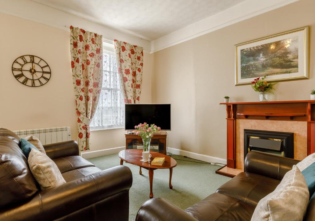 a living room with a couch and a fireplace at Tracy - Upcott House in Barnstaple