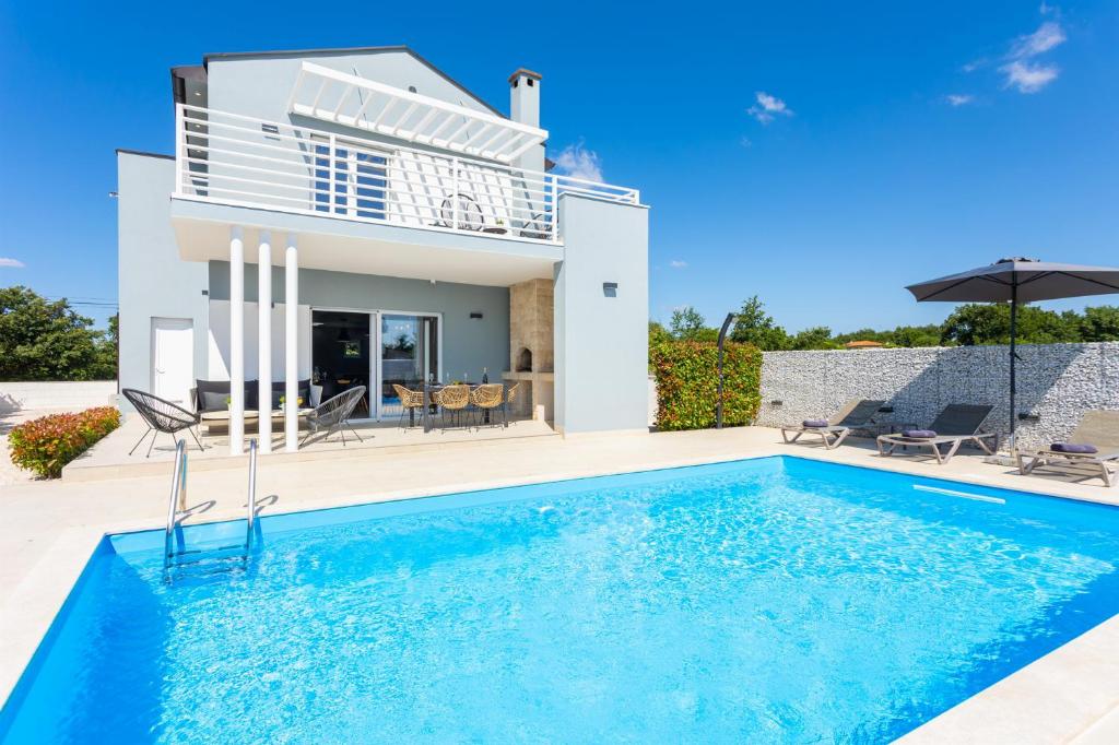 een villa met een zwembad voor een huis bij Villa Ovis in Peresiji