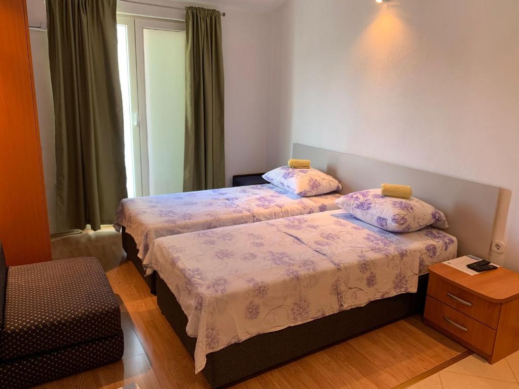 um quarto de hotel com duas camas e uma janela em Room Ivana em Neum