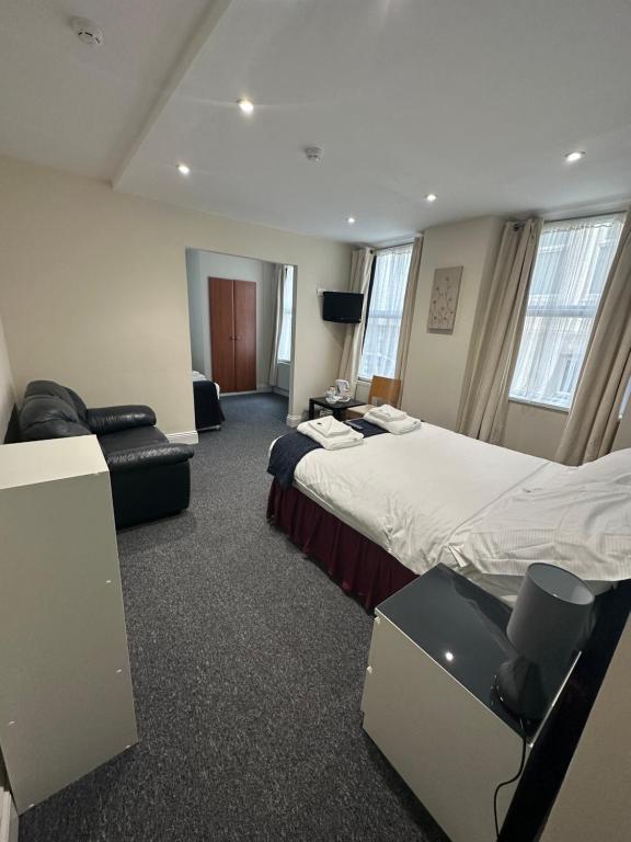 una camera d'albergo con due letti e una sedia di The Island & Fairfield a Douglas