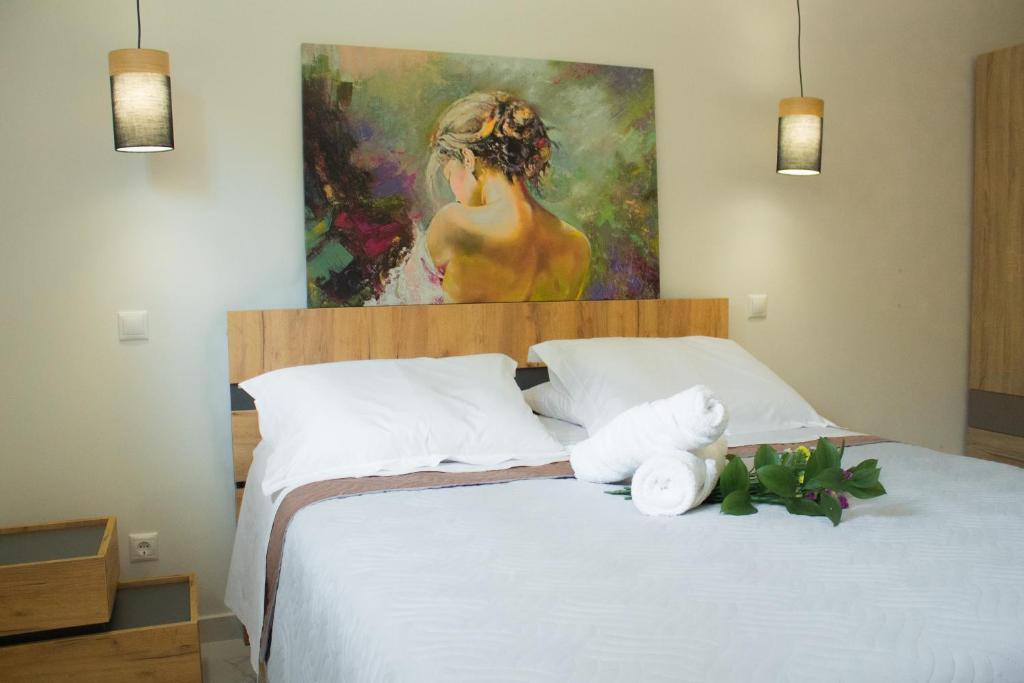 a bedroom with a bed with a painting on the wall at Elias Studio - Near to the port of Rafina and the Airport of Athens in Áyios Spirídhon
