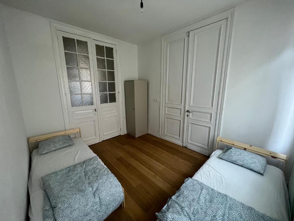 een lege kamer met twee bedden in een kamer bij Bkenkember Aprt in Antwerpen