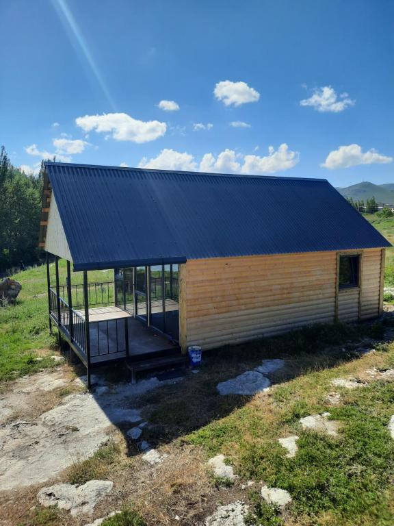 a small wooden building with a black roof at Nirok in Sevan