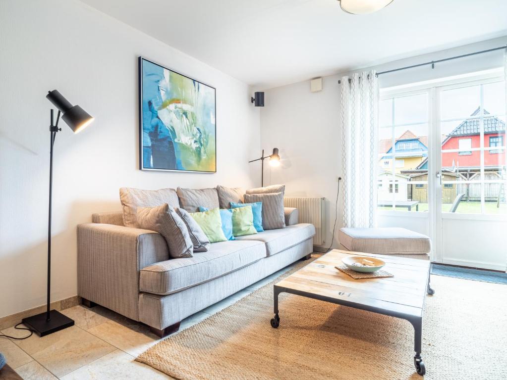 a living room with a couch and a coffee table at Residenz "Zu den 3 Tannen" 5 in Zingst