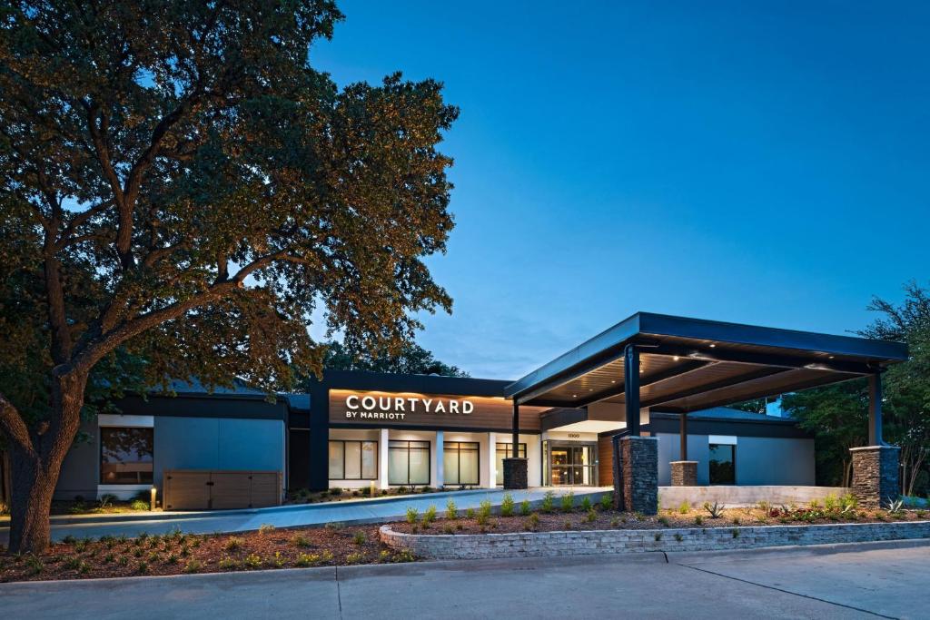 リチャードソンにあるCourtyard by Marriott Dallas Richardson at Spring Valleyの中庭を読む看板のある中庭の建物