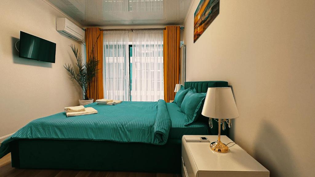 una camera con un letto blu e una finestra di Sea view Apartment a Mamaia