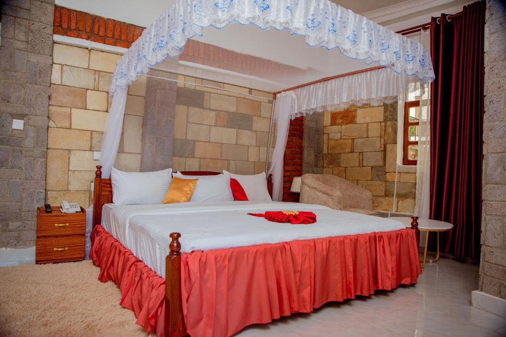 a bedroom with a large bed with a canopy at KIGUFI HILL, Agape Resort & Kivu Edge in Gisenyi