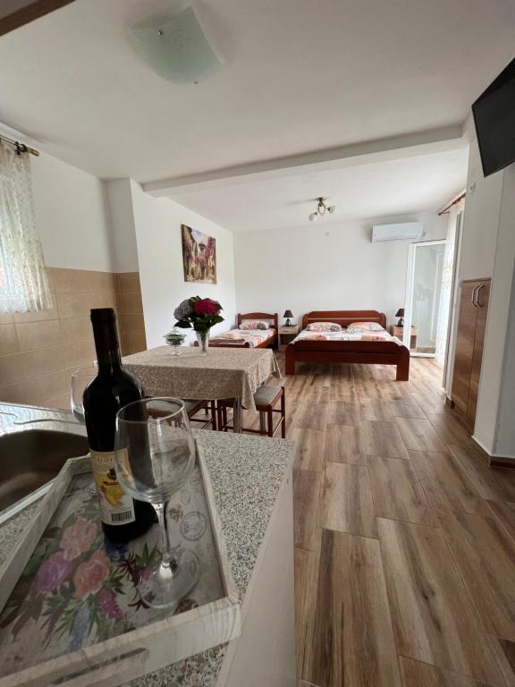 a kitchen and living room with a bottle of wine on a counter at Apartment Kovach Kuti in Herceg-Novi