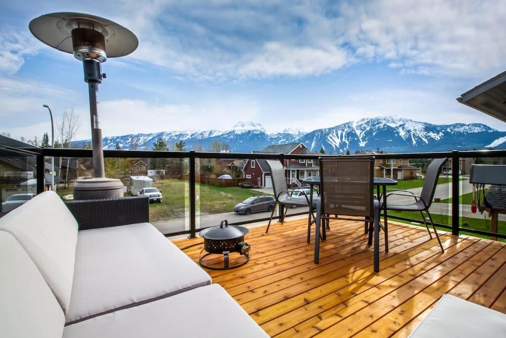 una terraza con mesa, sillas y montañas en The best 2 bedrooms suite in Revelstoke! en Revelstoke