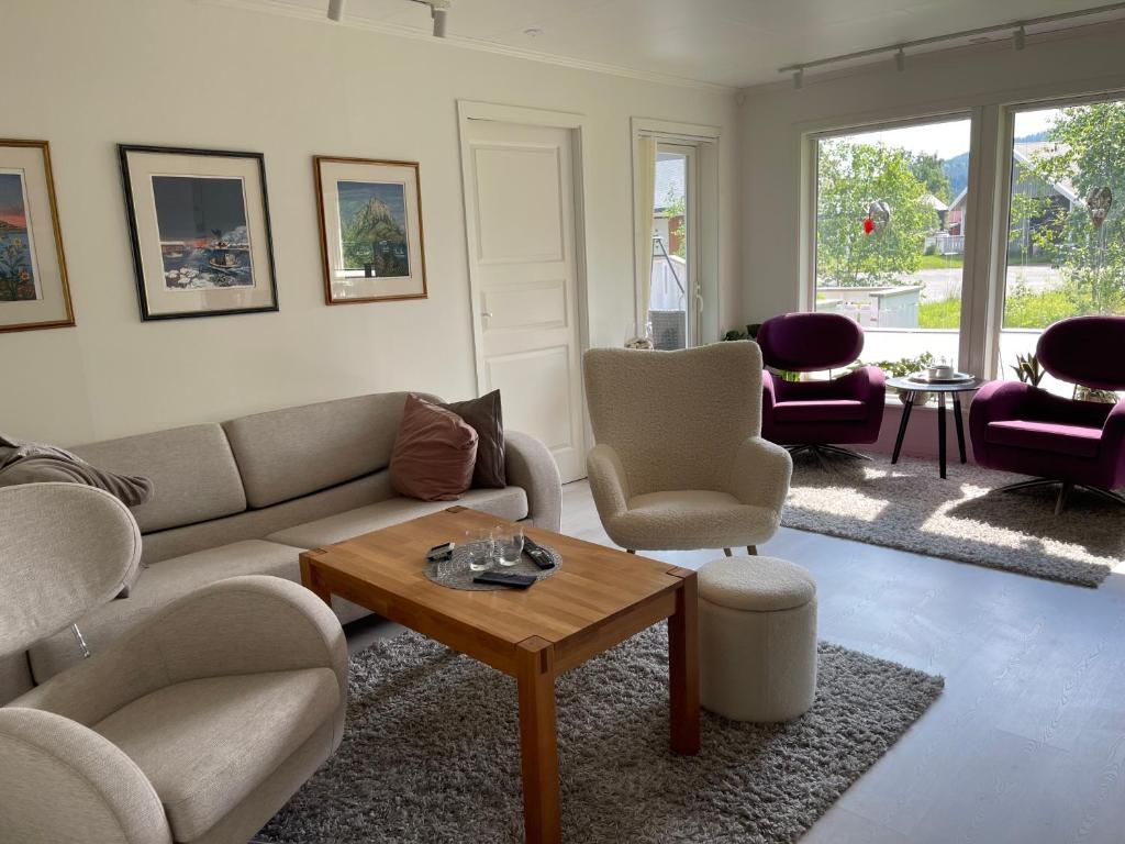 uma sala de estar com um sofá, cadeiras e uma mesa em Leilighet med 2 soverom em Rokland