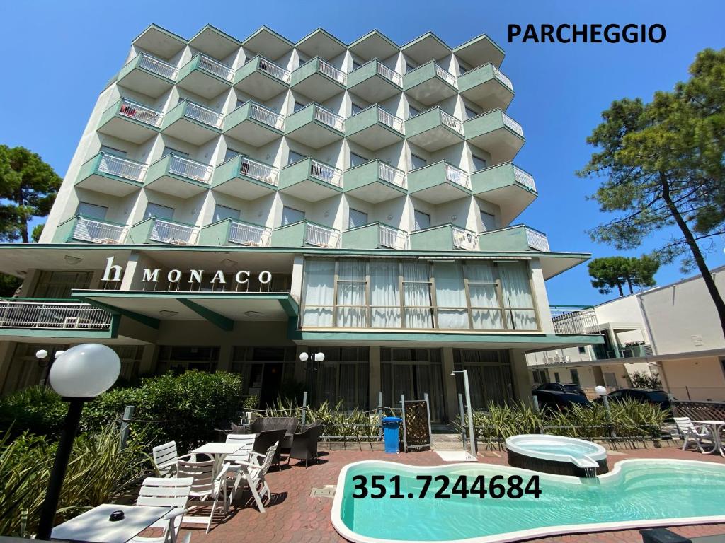 un hotel con piscina frente a él en Hotel Monaco, en Milano Marittima
