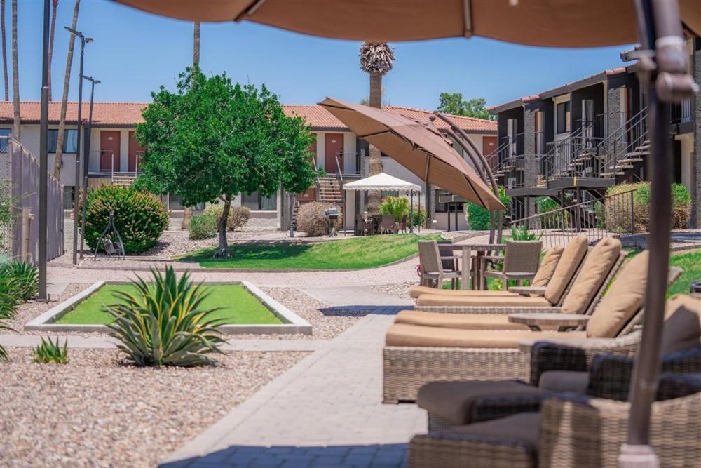 een patio met banken en tafels en een parasol bij 122 Fully Furnished 1BR Suite-Prime Location in Scottsdale