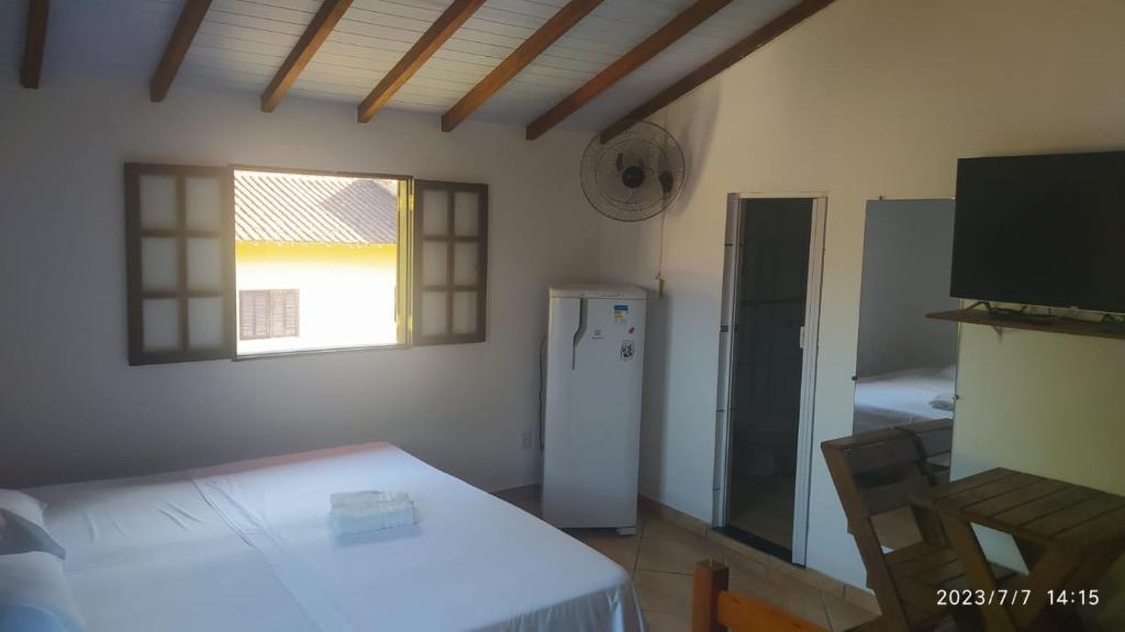 a small room with a refrigerator and a window at Pousada João e Maria in Trindade