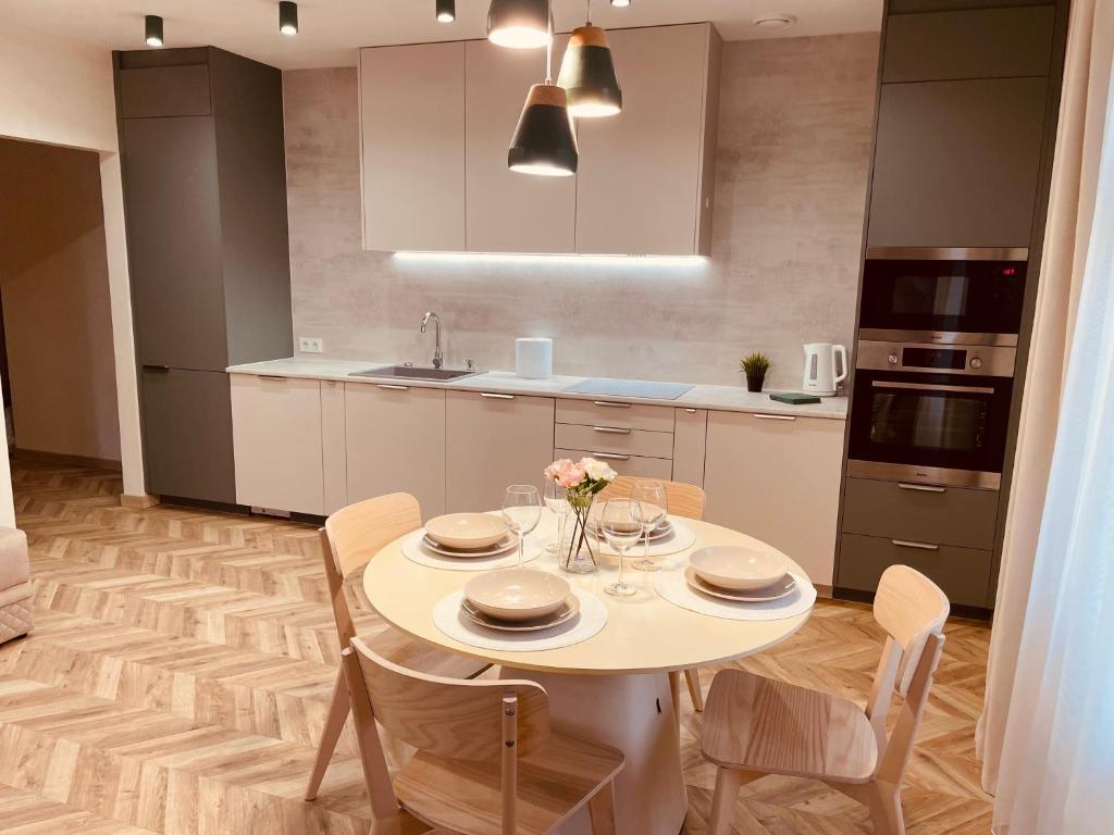 a kitchen with a table and chairs in a kitchen at KOBIELA APARTMENTS Family Delux KTW City Center in Katowice