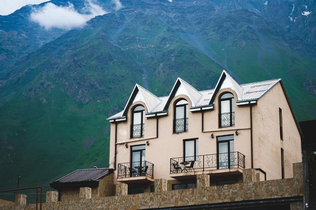 una casa con una montagna sullo sfondo di Hotel Toliketi a Kazbegi