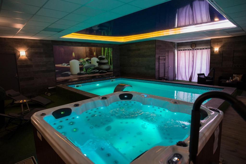 a large jacuzzi tub in a room with at COCOONING SPA - Gîte avec piscine, jacuzzi, sauna in Marck