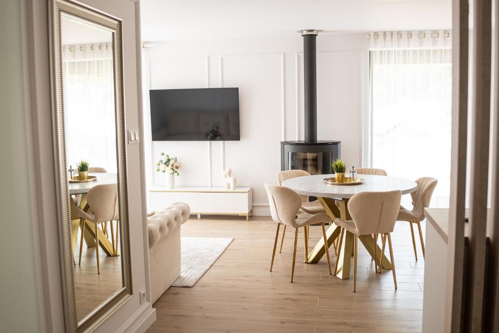 a white dining room with a table and chairs at Domki na wyłączność - Apartamenty Koziniec 5, Myczkowce, Solina, Bieszczady in Myczkowce