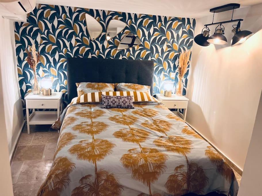 a bedroom with a bed with a blue and gold bedspread at Triplex de Saint-Paul Free public parking in Saint-Paul-de-Vence