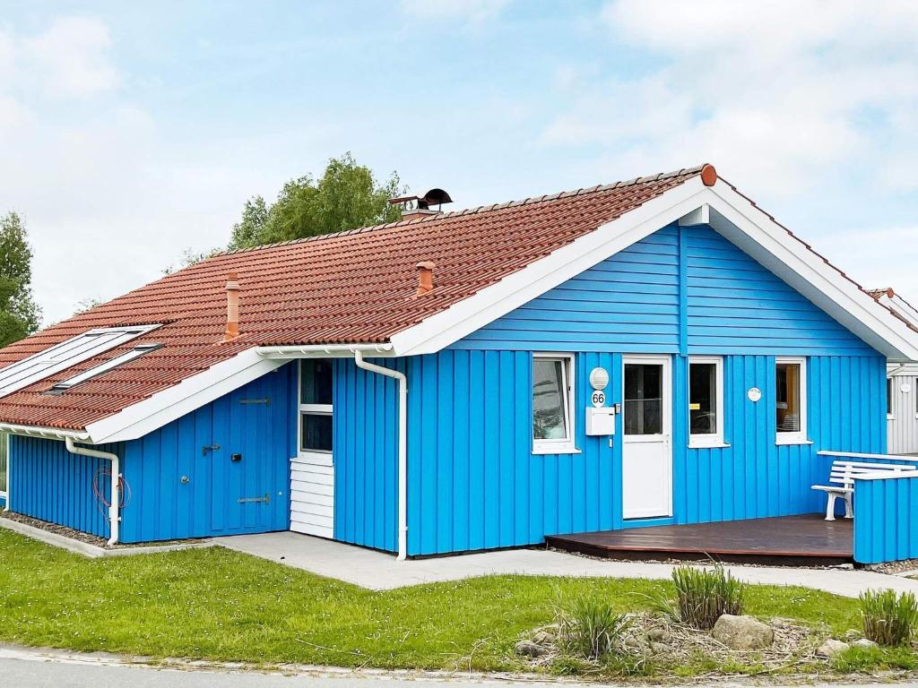 ein blaues Haus mit rotem Dach in der Unterkunft 12 person holiday home in Otterndorf in Otterndorf