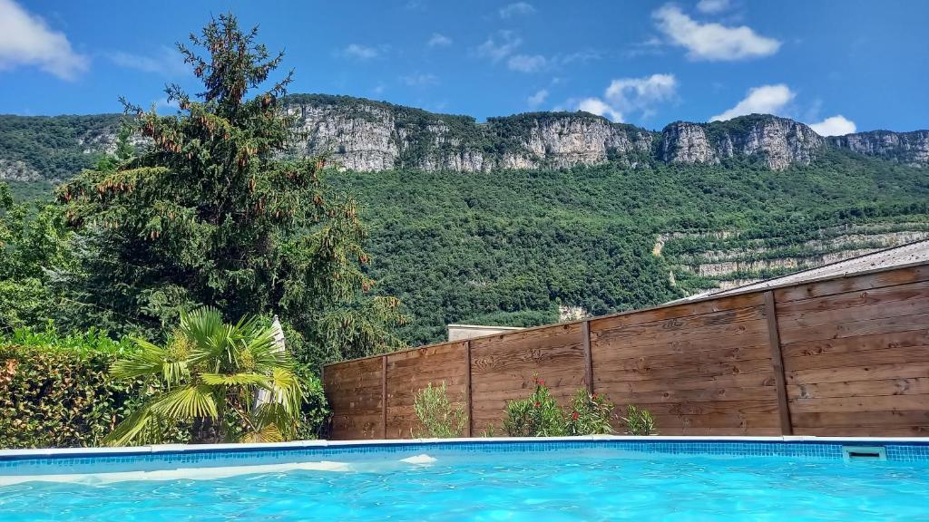 a swimming pool with a mountain in the background at Maison avec piscine entre Chartreuse et Vercors in La Buisse