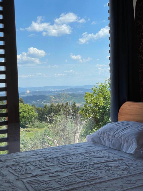 a bedroom with a bed and a window with a view at AltaVista in Vitorino dos Piães