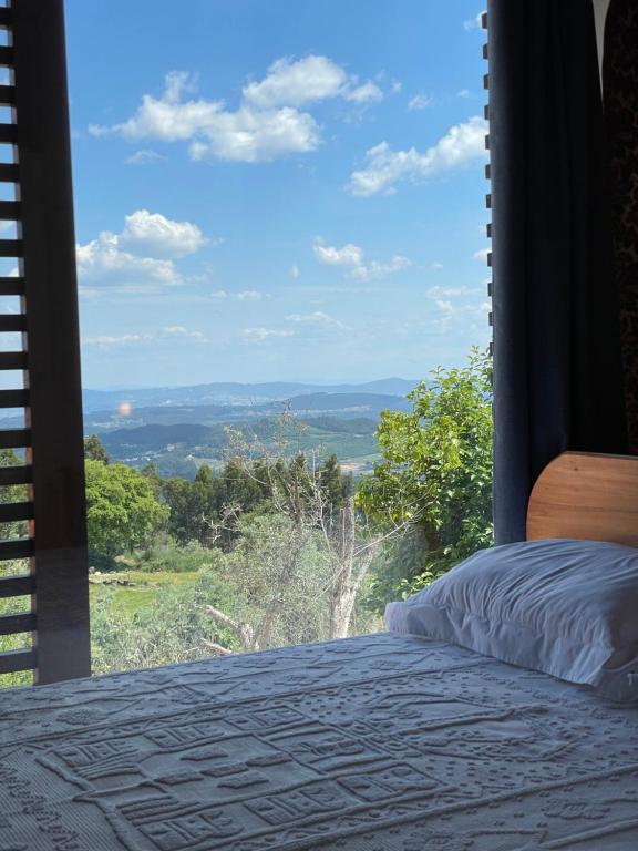 ein Schlafzimmer mit Bett und Fenster mit Aussicht in der Unterkunft AltaVista in Vitorino dos Piães