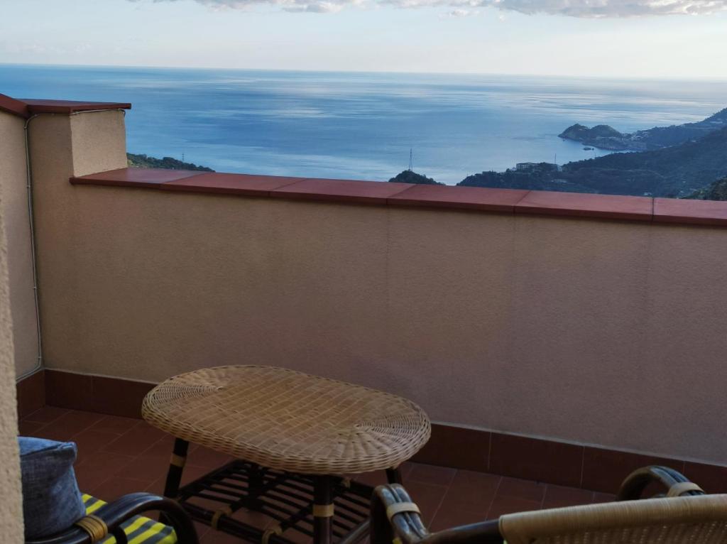 une table et une chaise assises sur un balcon dans l'établissement La Panoramica, à Gallodoro