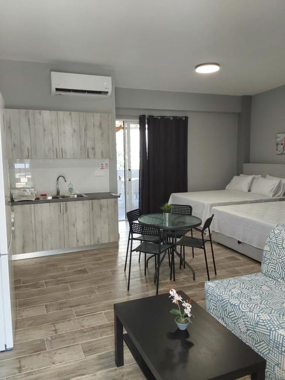 a living room with a bed and a couch and a table at Vasiliki Studios Tolo in Tolo