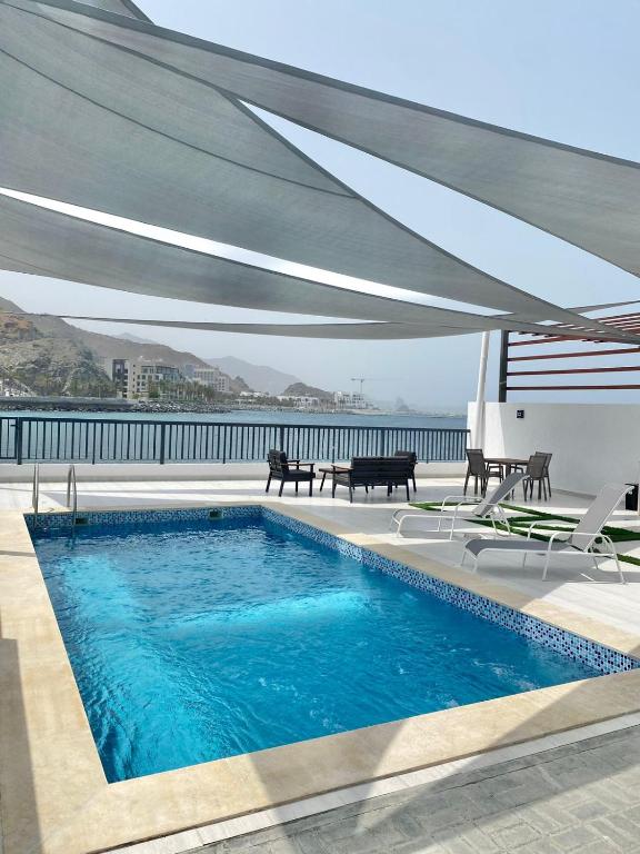 a swimming pool with a large canopy over it at The Pearl Villa 5 bedrooms with pool Sea and Mountain View in Fujairah