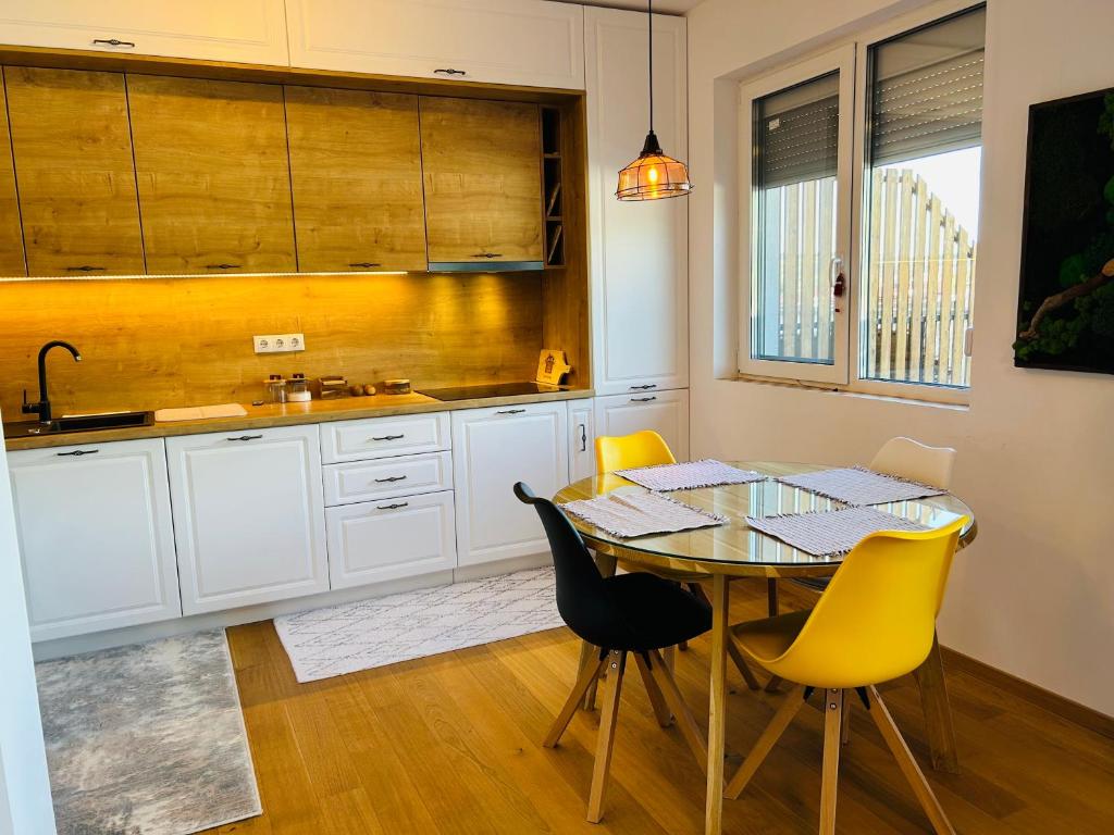 a kitchen with a table and yellow chairs at Lizz Panoramic Residence in Floreşti