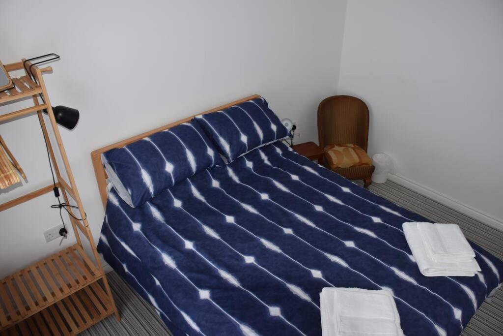 a large blue bed with two white towels on it at Cosy Coastal Cottage in Portballintrae in Portballintrae