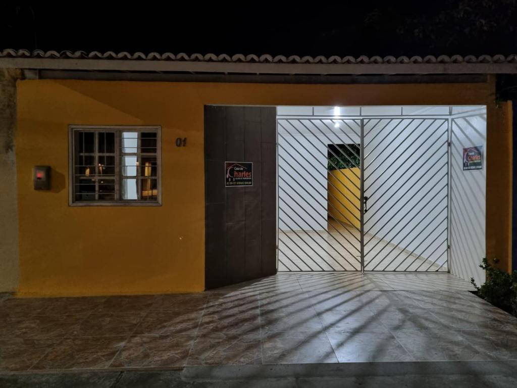 un bâtiment jaune et blanc avec une porte dans l'établissement Casa de Charles, à Piranhas