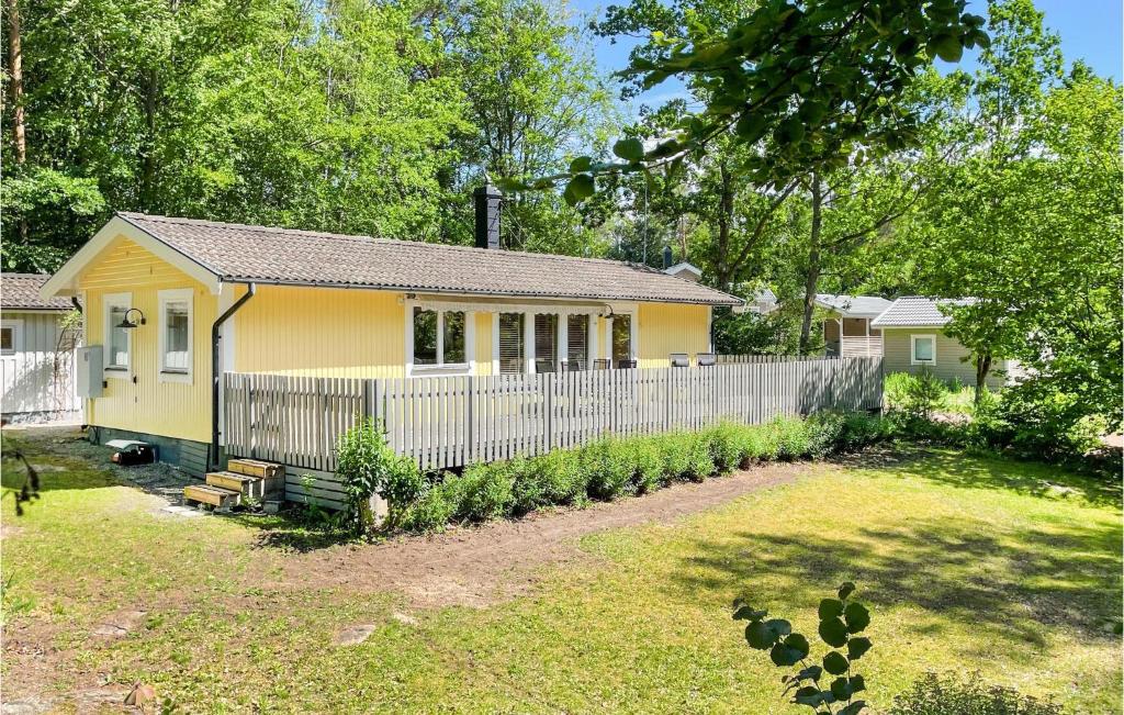 uma casa amarela com uma cerca num quintal em 3 Bedroom Nice Home In Fjlkinge em Fjälkinge