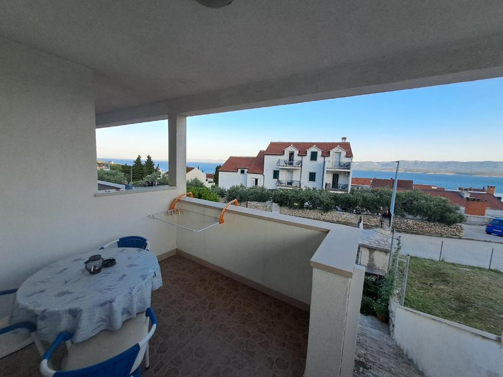 balcón con mesa y vistas al océano en Apartments Igor, en Bol