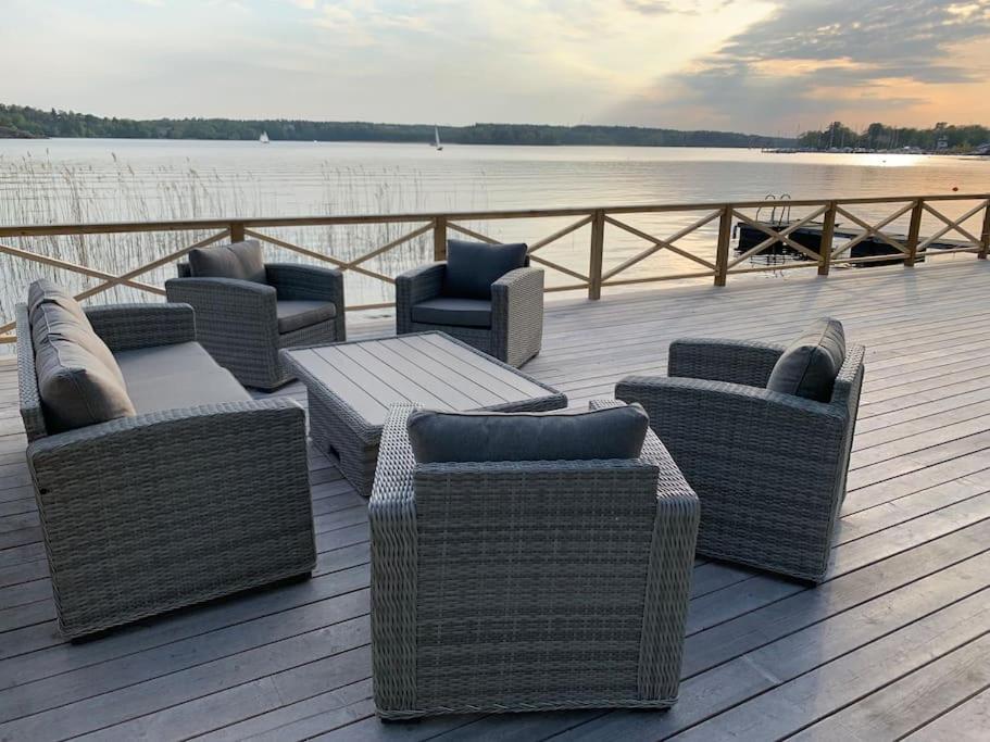 un grupo de sillas y una mesa en un muelle en Waterfront house with jacuzzi & jetty in Stockholm en Estocolmo