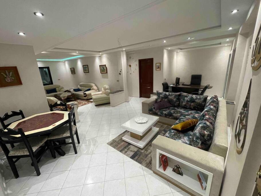 ein Wohnzimmer mit einem Sofa und einem Tisch in der Unterkunft Superbe appart à côté de la plage et du centre in Tangier