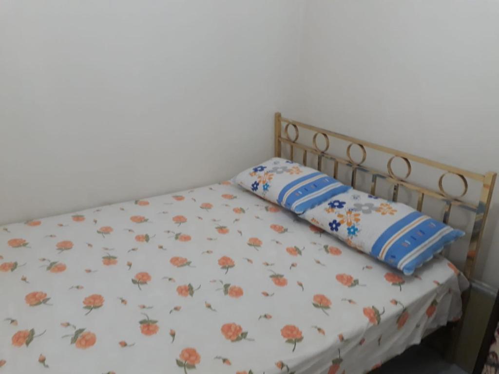 a bed with a floral bedspread and a pillow on it at SARIMSAKLI PLAJINA 0 METRE DENİZ MANZARALI LÜX DAİRE in Ayvalık