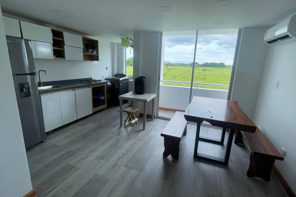 ein Wohnzimmer mit einem Tisch und einer Küche in der Unterkunft Caribe Campestre coveñas in Coveñitas