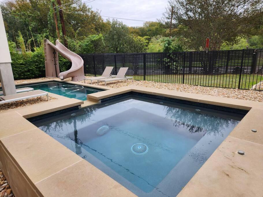 a swimming pool with a slide in a backyard at central contemporary w/ POOL and SPA in Austin