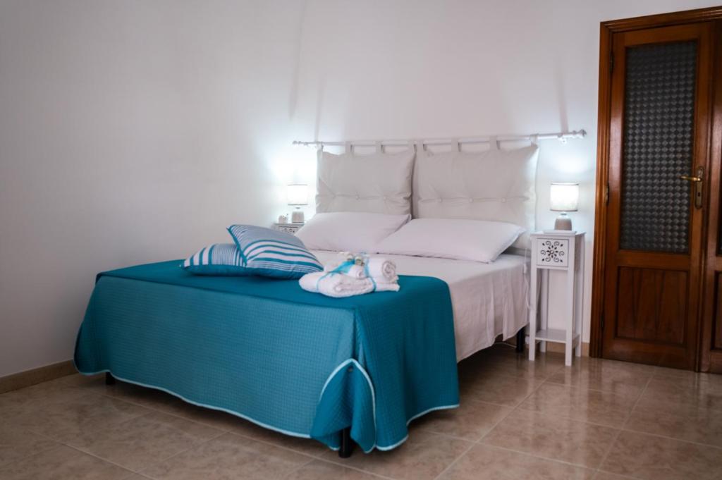 a bedroom with a bed with a blue table with a stuffed animal on it at Casa GianAngel Ostuni in Ostuni
