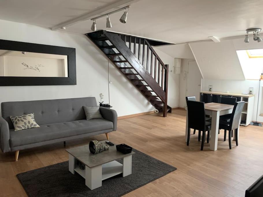 a living room with a couch and a table at Duplex très charmant in Melun