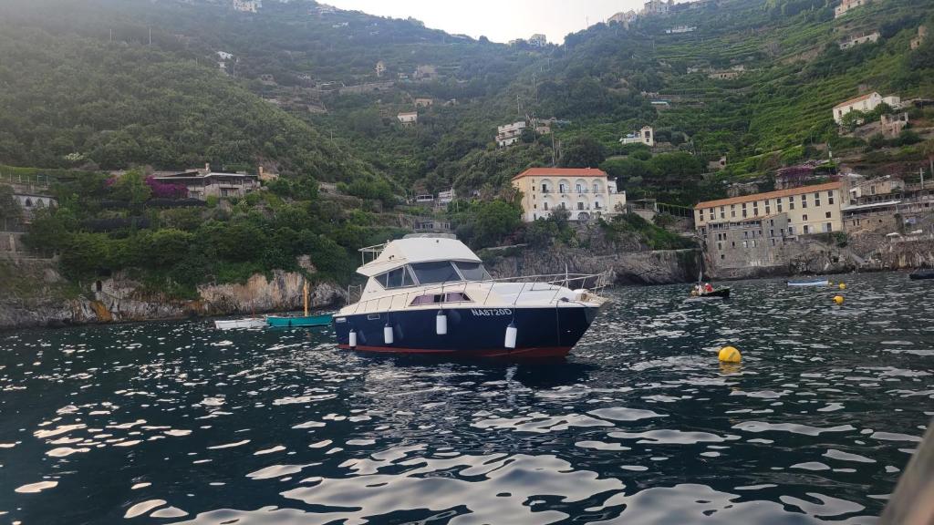 a boat sitting in the water near a city at Amalfi Coast Yacht in Minori
