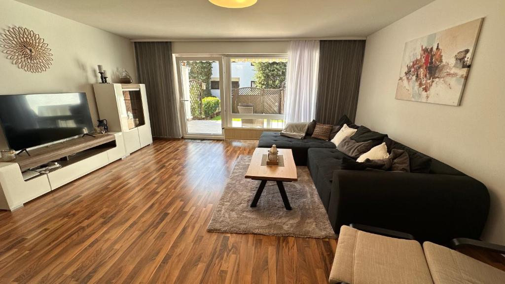 sala de estar con sofá, TV y mesa en Haus mit 4 Schlafzimmer, Wohnzimmer und Küche, en Heusenstamm