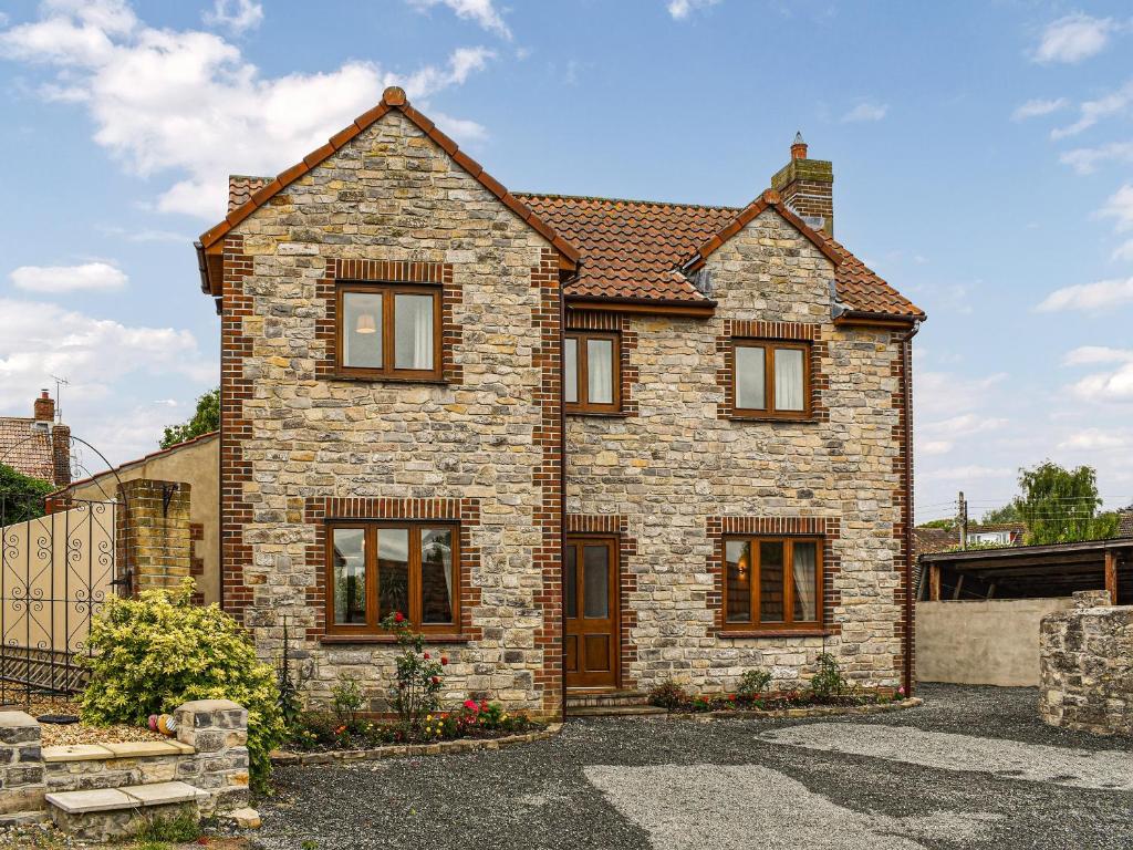 a large brick house with a driveway at Swift Cottage in Chilton Polden 