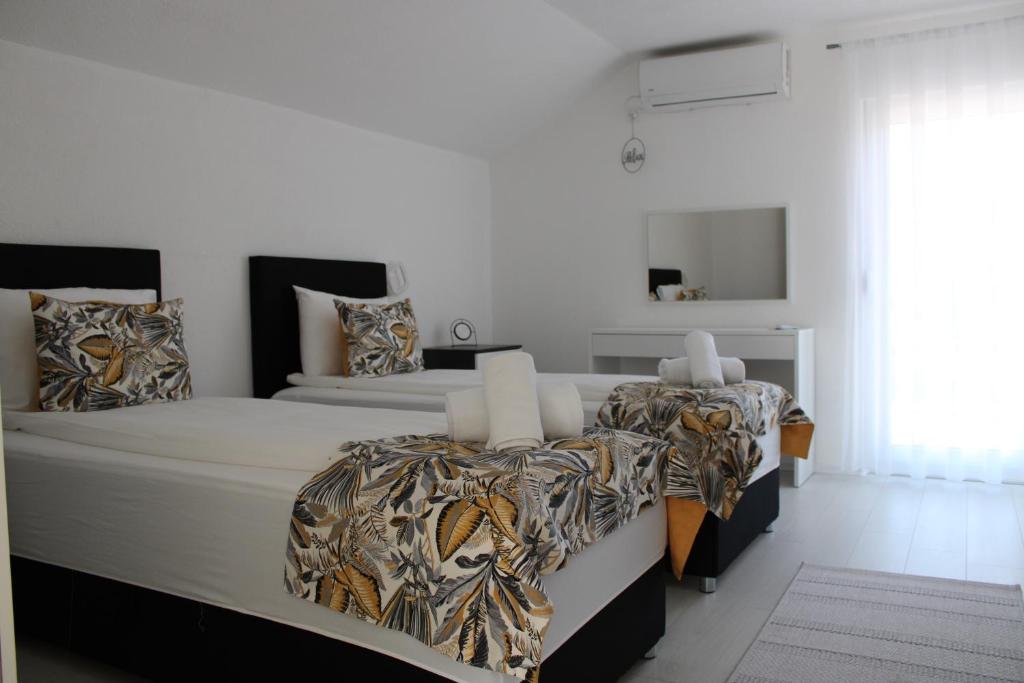 1 dormitorio blanco con 2 camas y ventana en AM Una Lux House, en Bihać