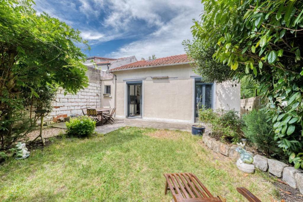 une arrière-cour avec une maison et une cour avec une cour dans l'établissement Maison au calme à 10 minutes à pied du métro ligne 11, à Romainville