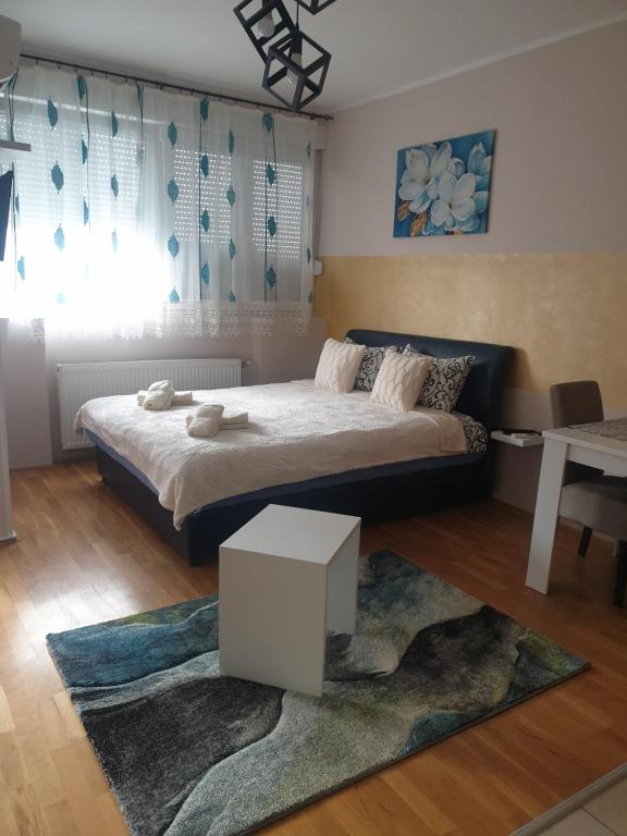 1 dormitorio con 1 cama grande y 1 alfombra en Aurora 2, en Novi Sad